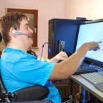 Man with infantile cerebral palsy using a computer.